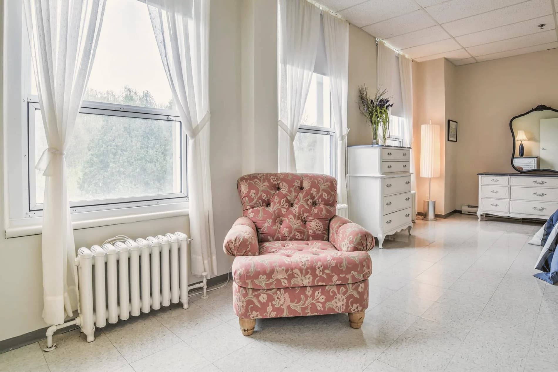 Une chambre claire avec un fauteuil près de la fenêtre